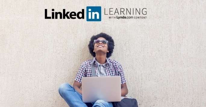 A student on campus in Career studio on computer, LinkedIn logo